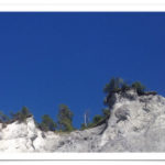 Brüchiger, grauer, fast weißer Fels in der Rheinschlucht vor blauem Himmel