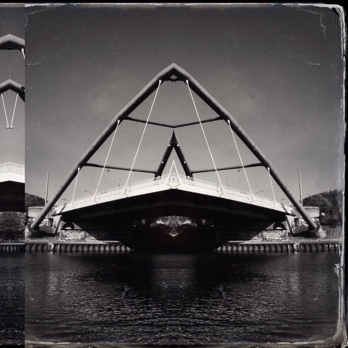 Black and white photo of a modern bridge, vertically mirrored